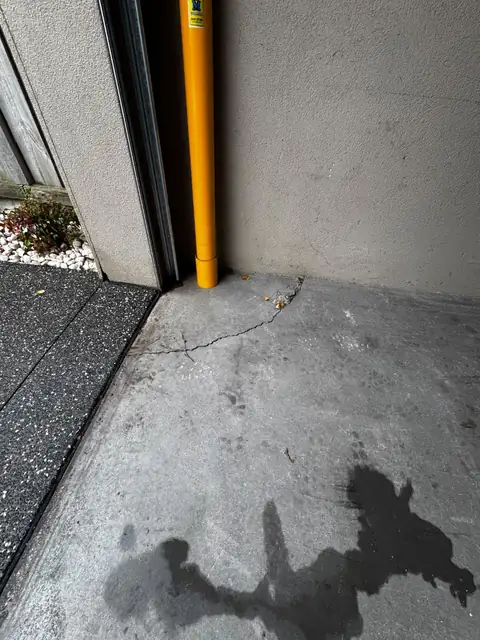 Cracked concrete slab corner before repair
