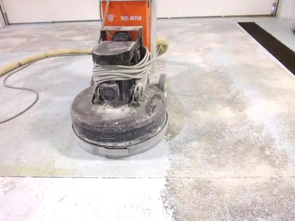 Grinder removing tile adhesive lines from concrete slab, project reference